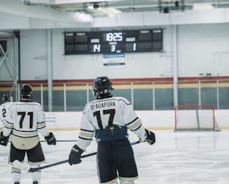 Two hockey players are on an ice rink, one with the name 'Spadafora' and number 17 on their jersey, and another with number 71. The score displayed on the scoreboard is Home 14, Guest 1, with the period indicated as 3 and the remaining time as 18:25.